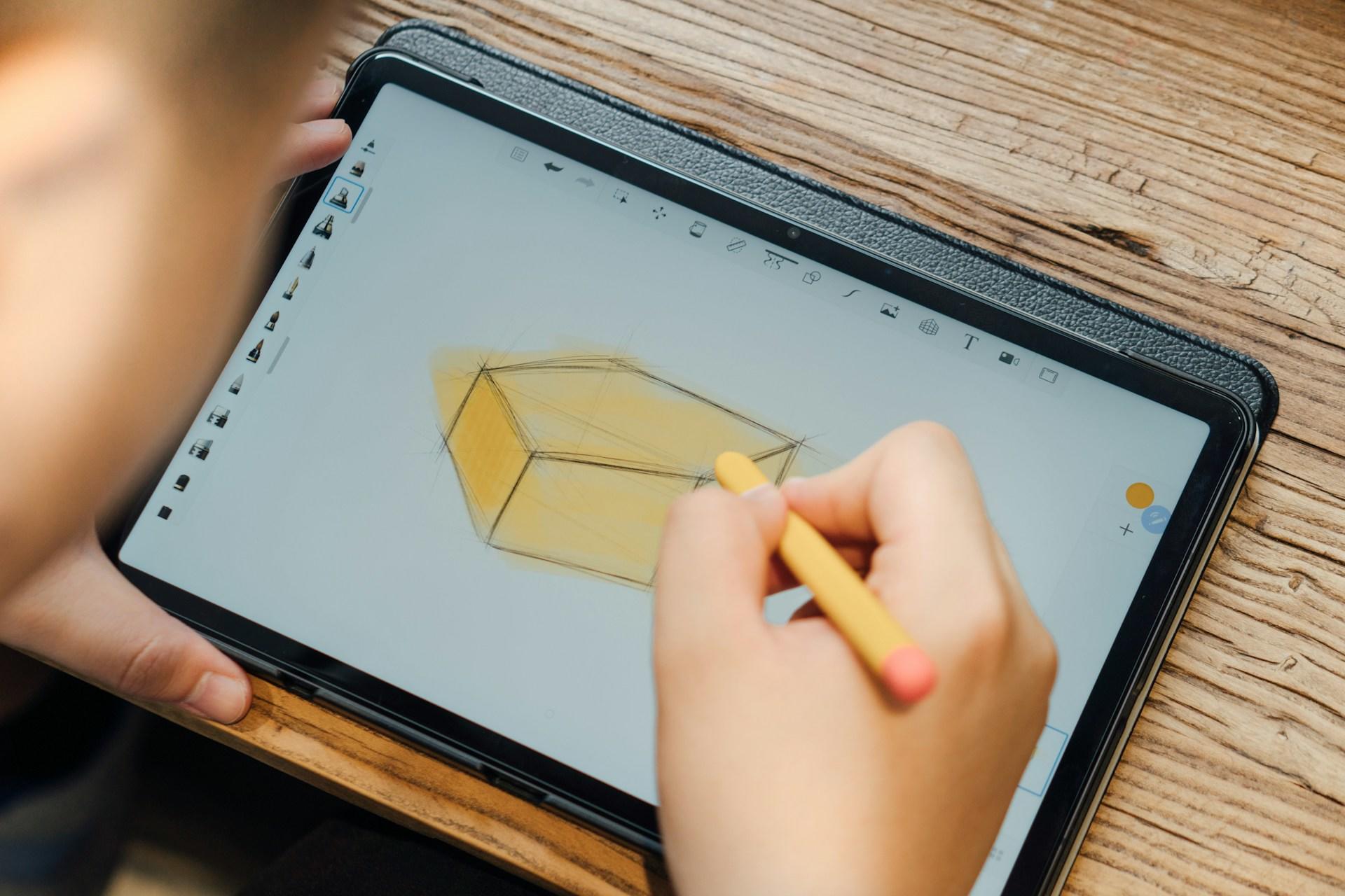 A person draws a geometric shape on a tablet.