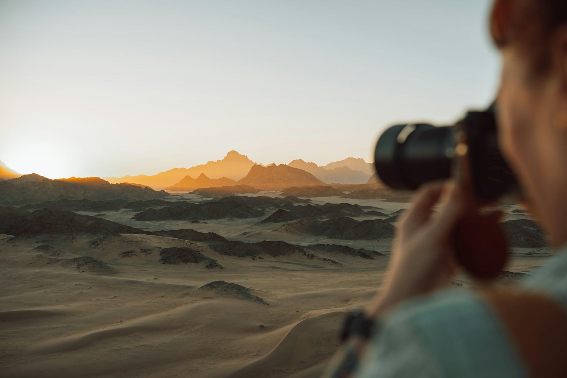A person taking a photo of a desert.