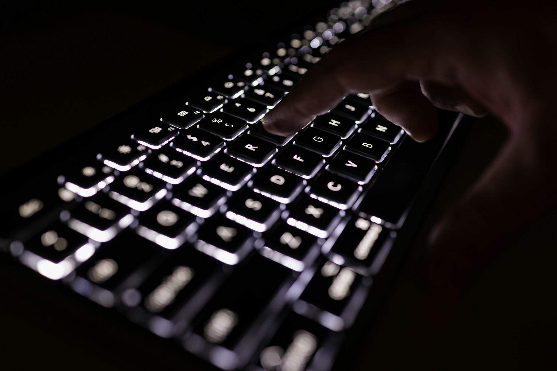A person typing on a black keyboard.