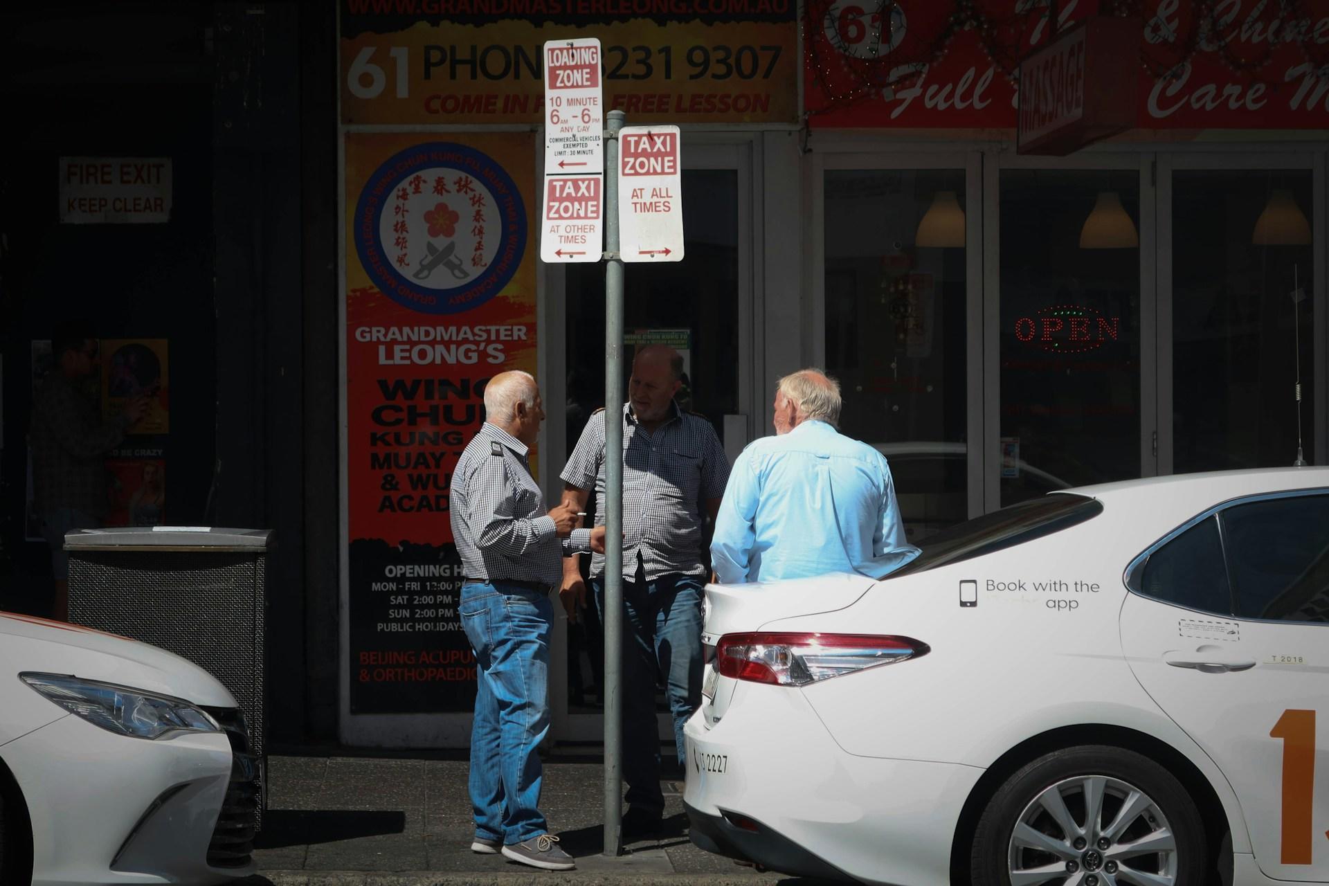 People waiting by a taxi.