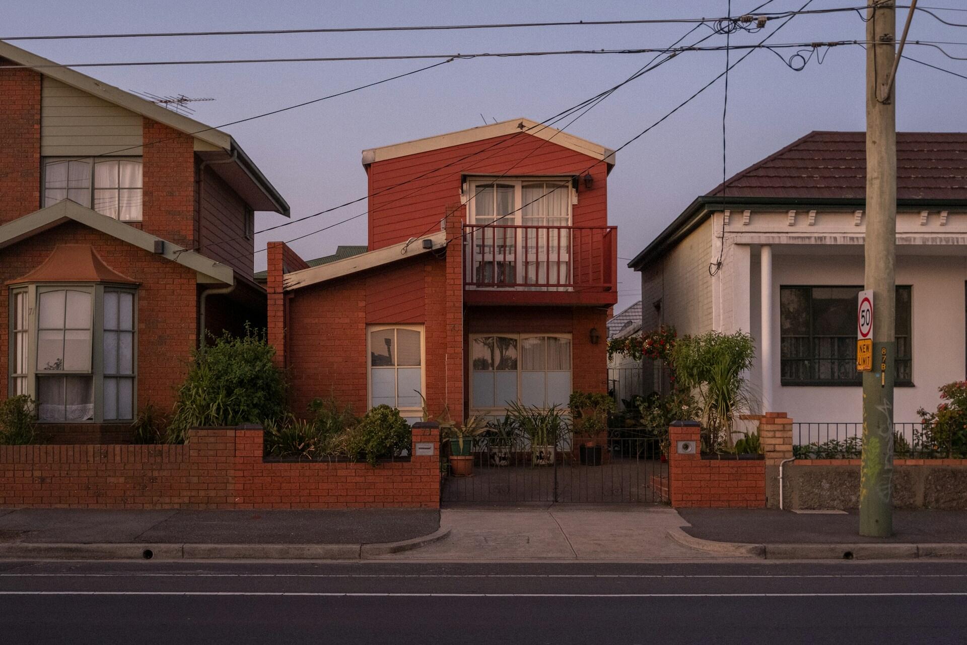 Row of houses on a residential street with a red building in the centre