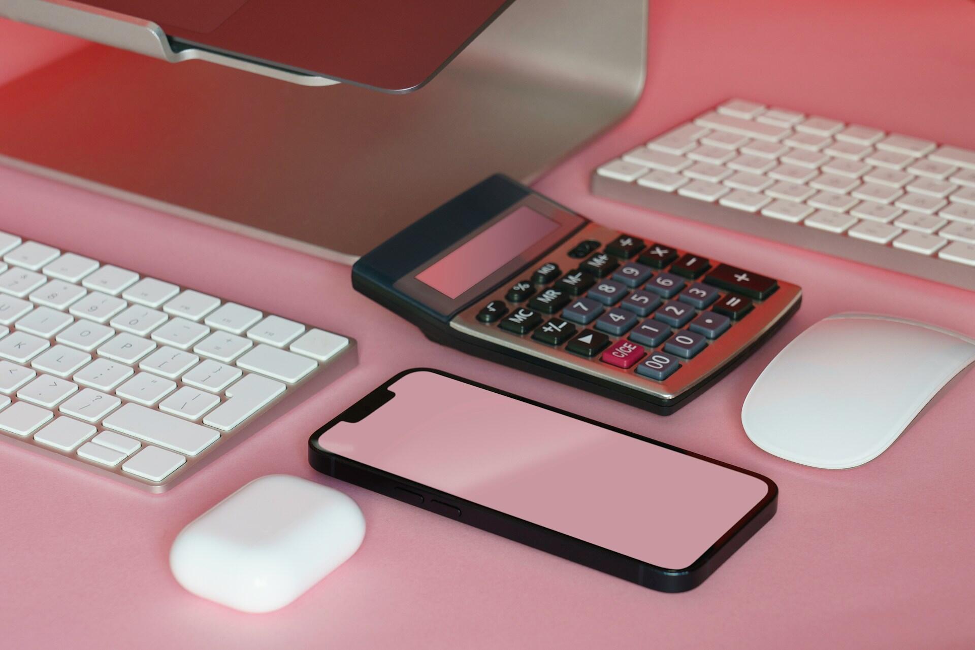 Calculator on desk with keyboard and smartphone