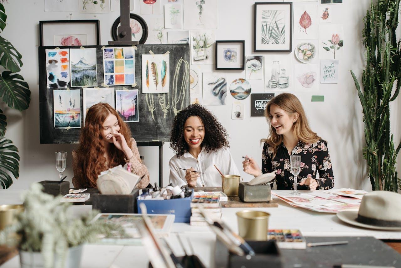 Three women painting together in an art studio