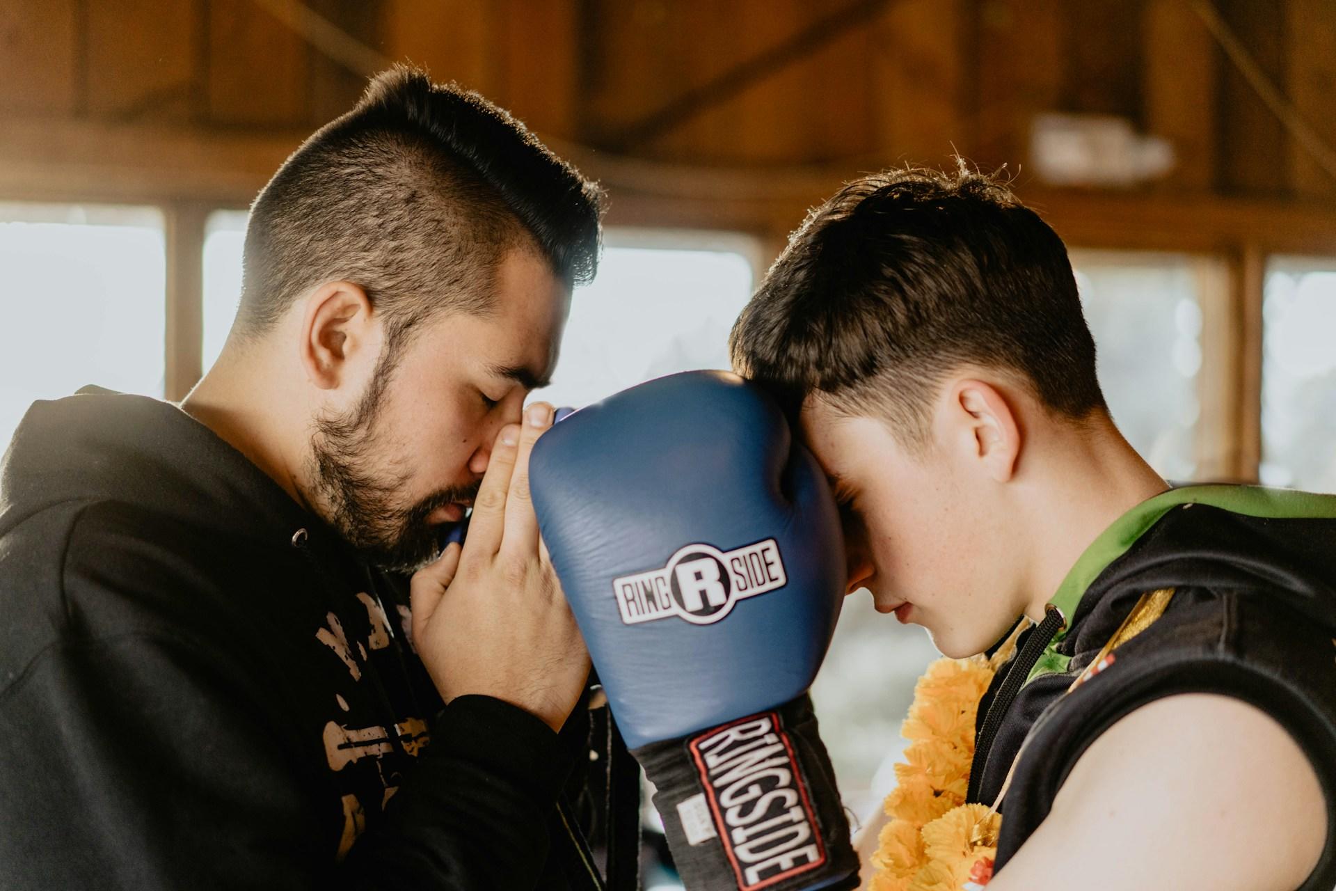 A boxing coach mentally preparing for training with his student.