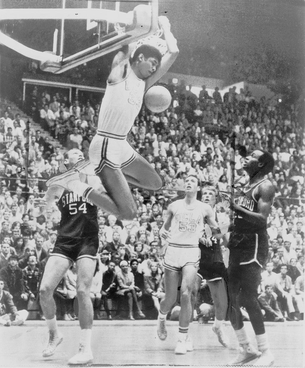 an old photo of Kareem Abdul-Jabbar dunking a basketball behind his head