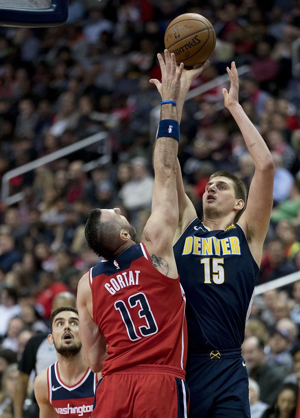 Nikola Jokic with the Denver Nuggets attempts a jump shot as Marcin Gortat tries to block during a game against the Washington Wizards on March 23, 2018.