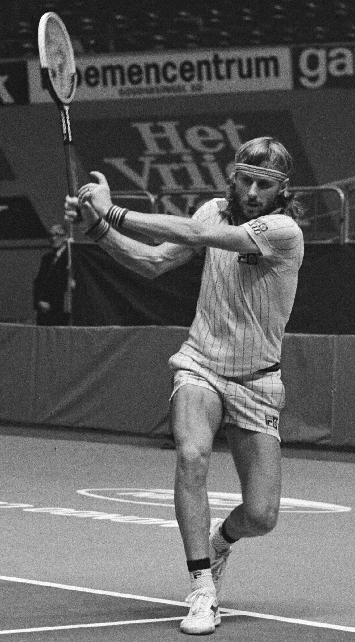 A male tennis player returning the ball. 
