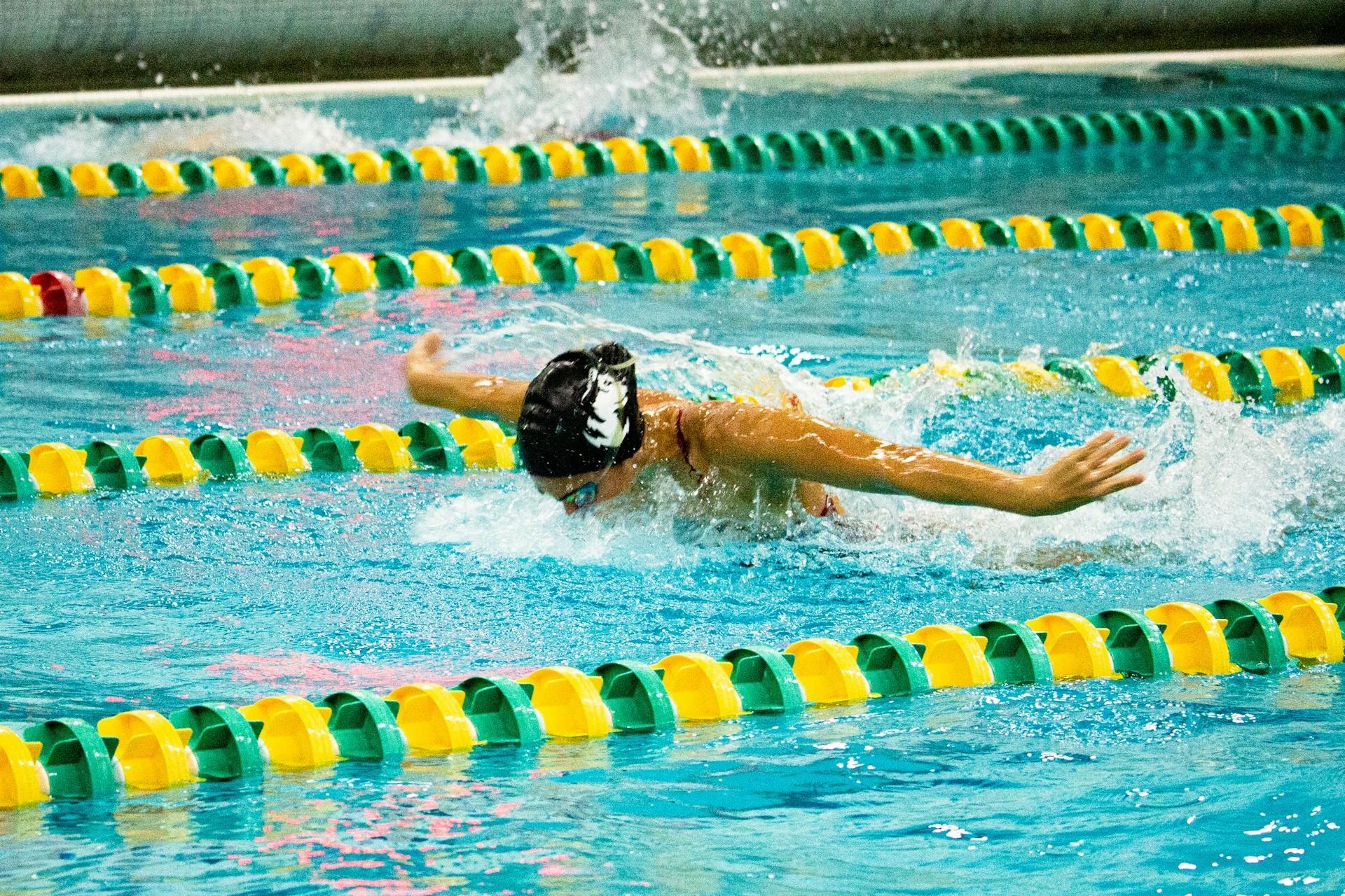 A swimmer doing the butterfly stroke in a lane.