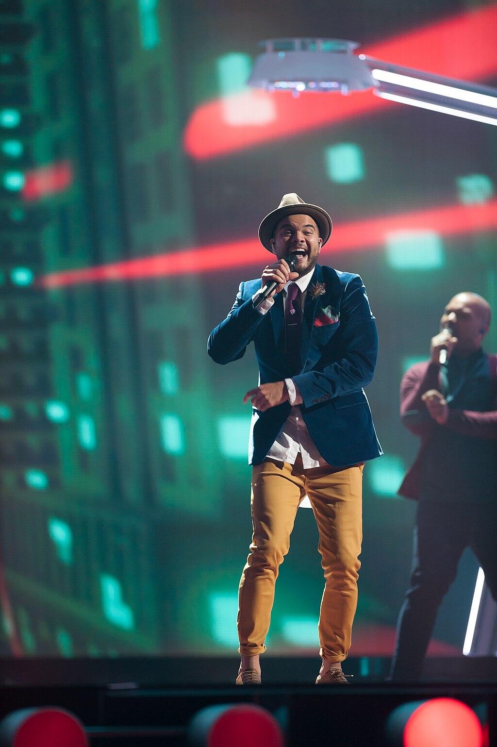 Guy Sebastian performing on stage with a light show