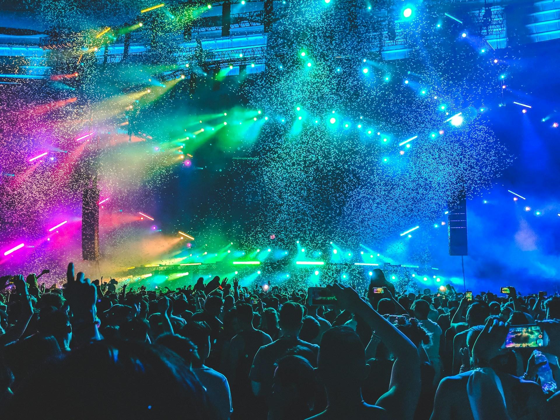 A lively concert crowd with confetti raining down, creating a vibrant and celebratory atmosphere.