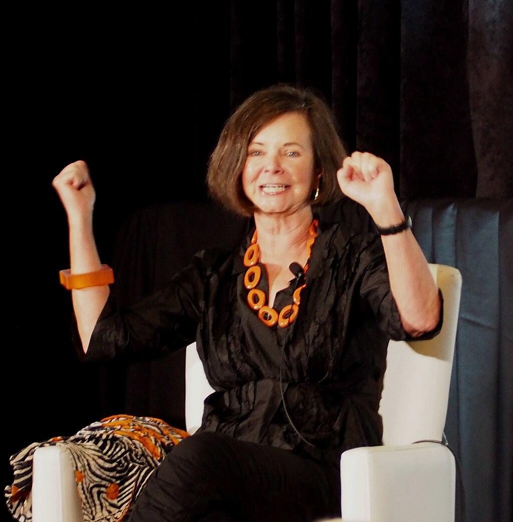 A women sitting in a white armchair and talking