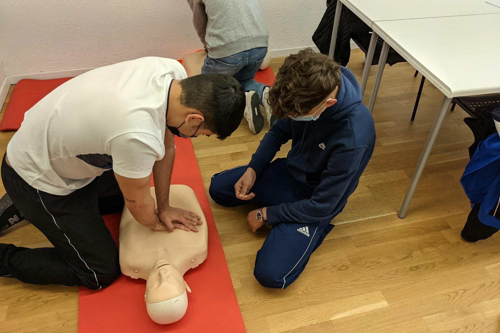 A person being shown how to perform CPR.