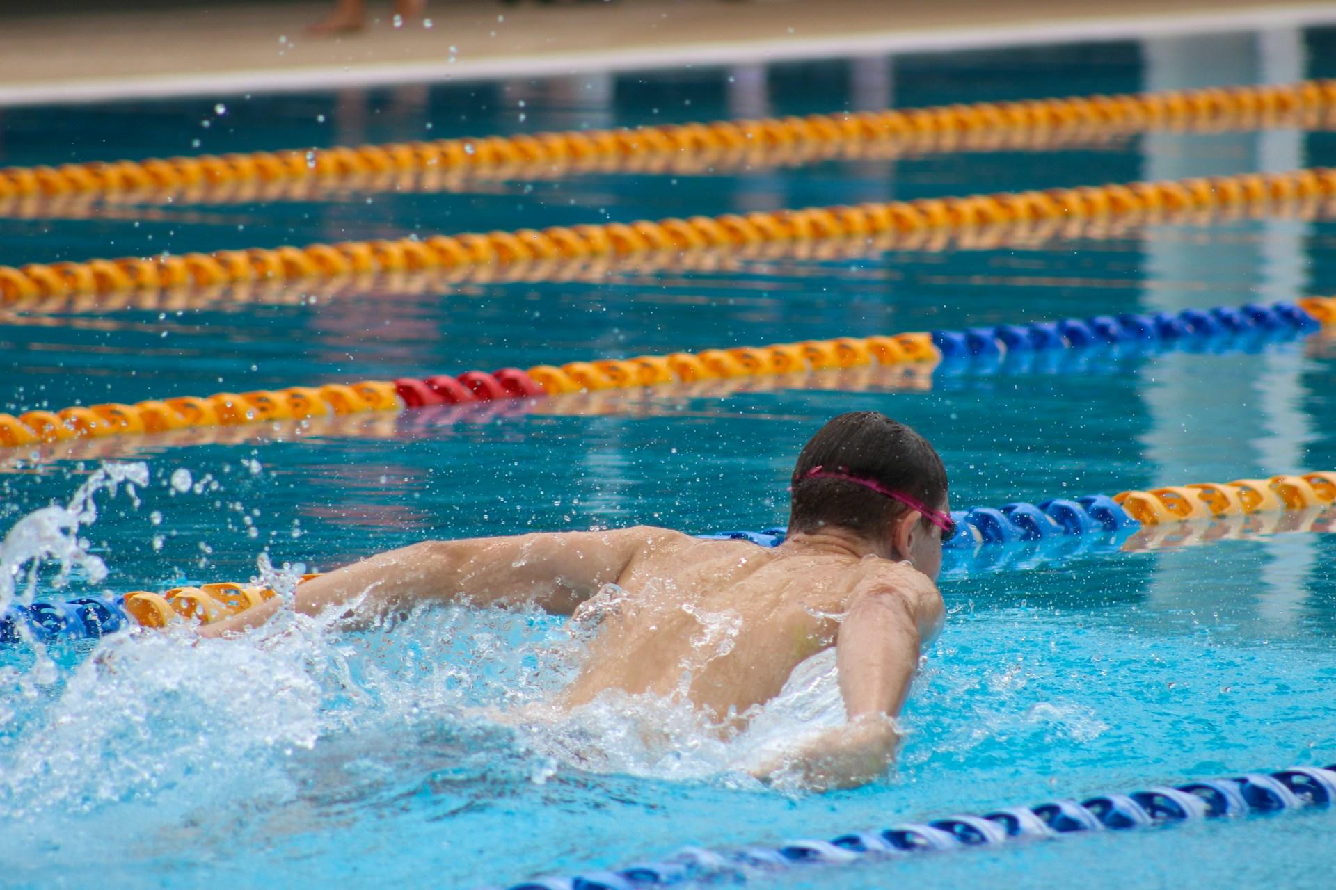 A swimmer doing the butterfly stroke in a swimming pool.