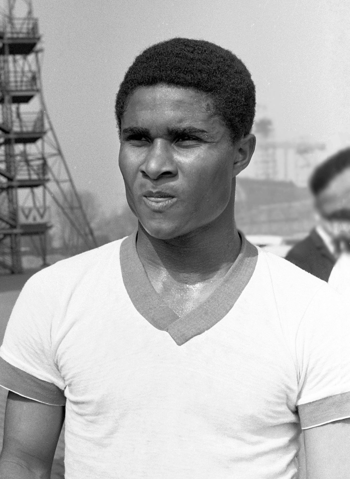 A greyscale image of a man in a white tee-shirt on a hot day.