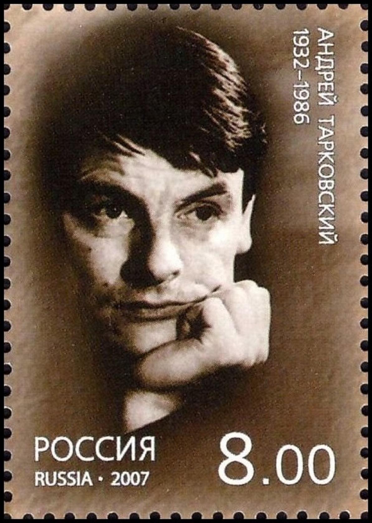 A sepia-toned image of a stamp featuring a man propping his chin in his hand and looking pensive.