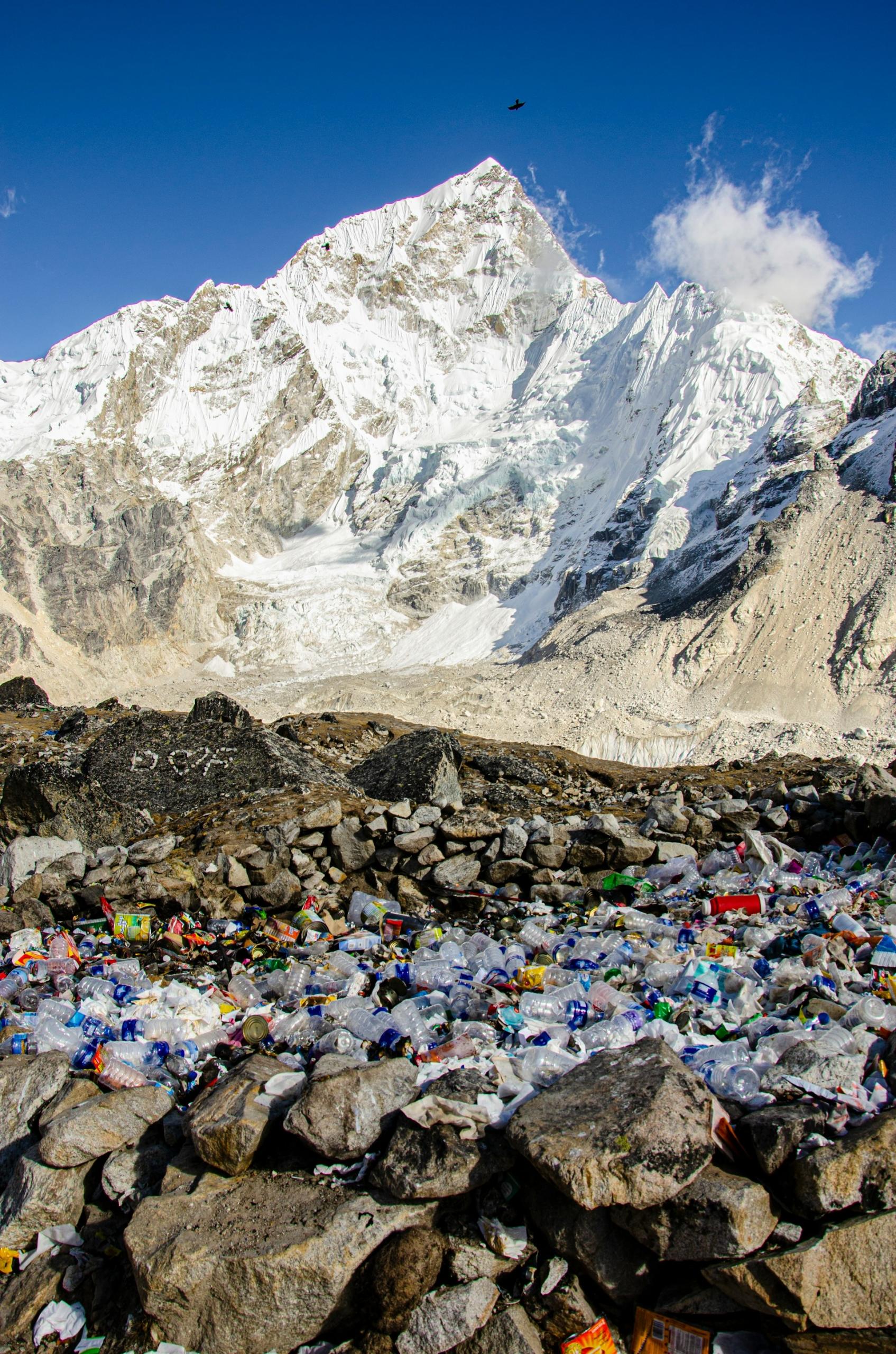 A litter of plastic waste on a plateau near a mountain peak on a sunny day. 