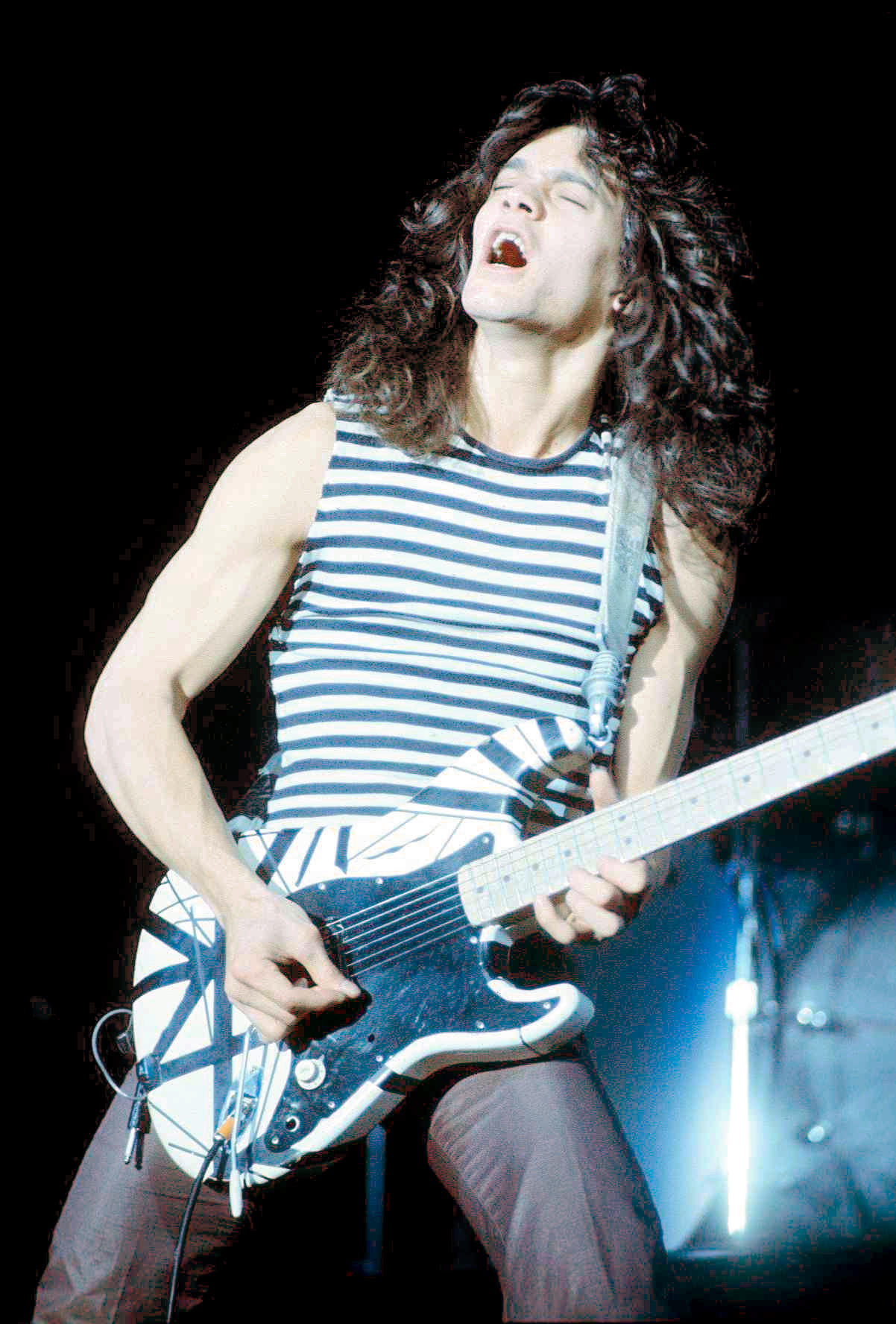 Eddie Van Halen playing guitar on stage.