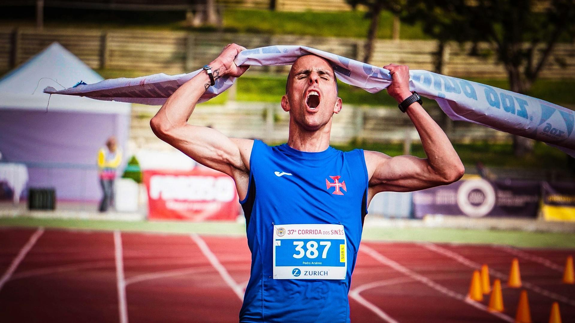 A man crossing the finish line at a running race