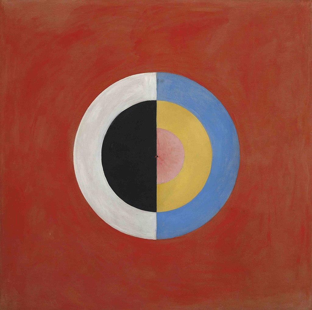 Against a red-orange background, a circle made of the colors black, white, pink, orange, and blue sits