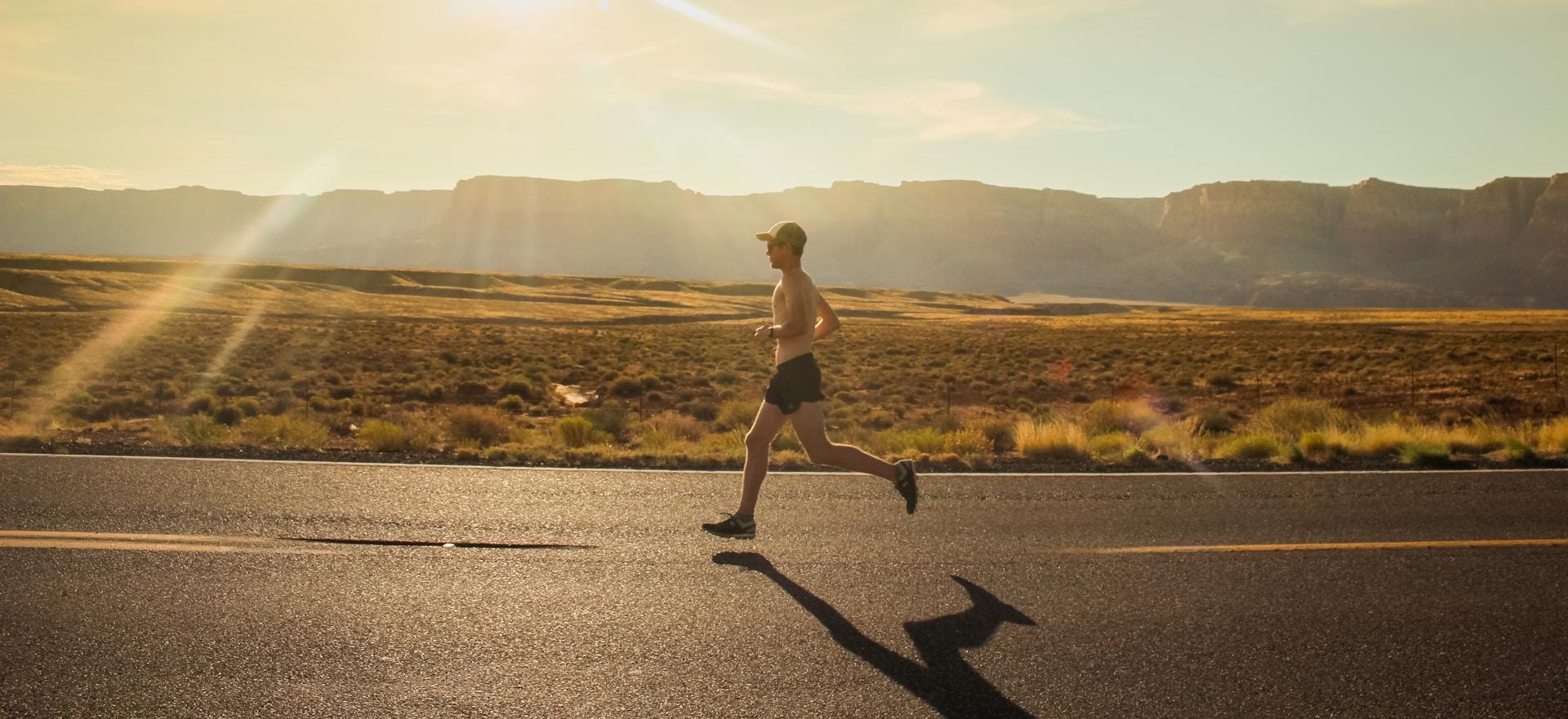 A man running on a road in the desert