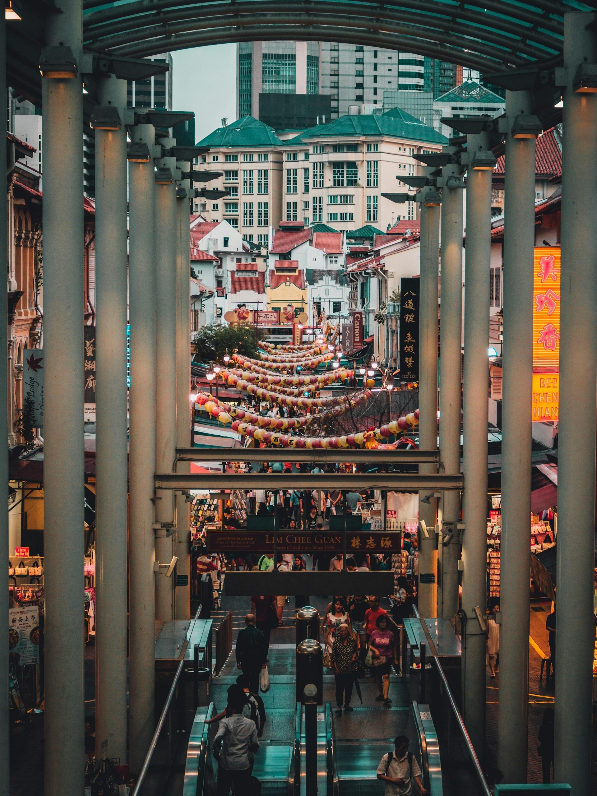 People gathering on the streets surrounded by stalls and buildings.