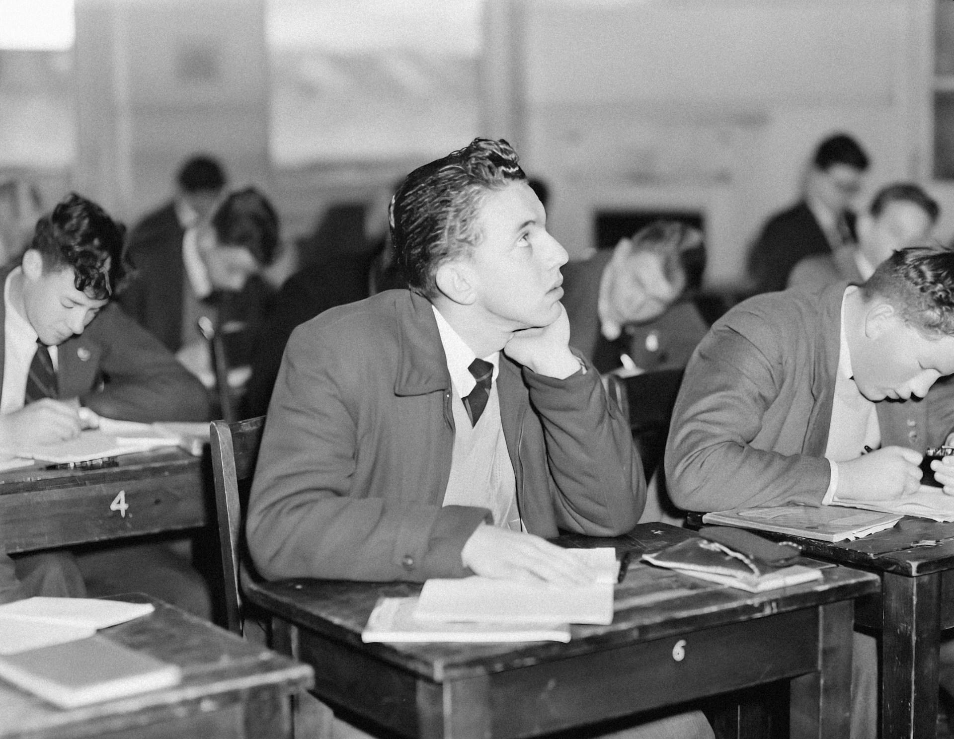 A group of teenage boys sitting at desks in a classroom.