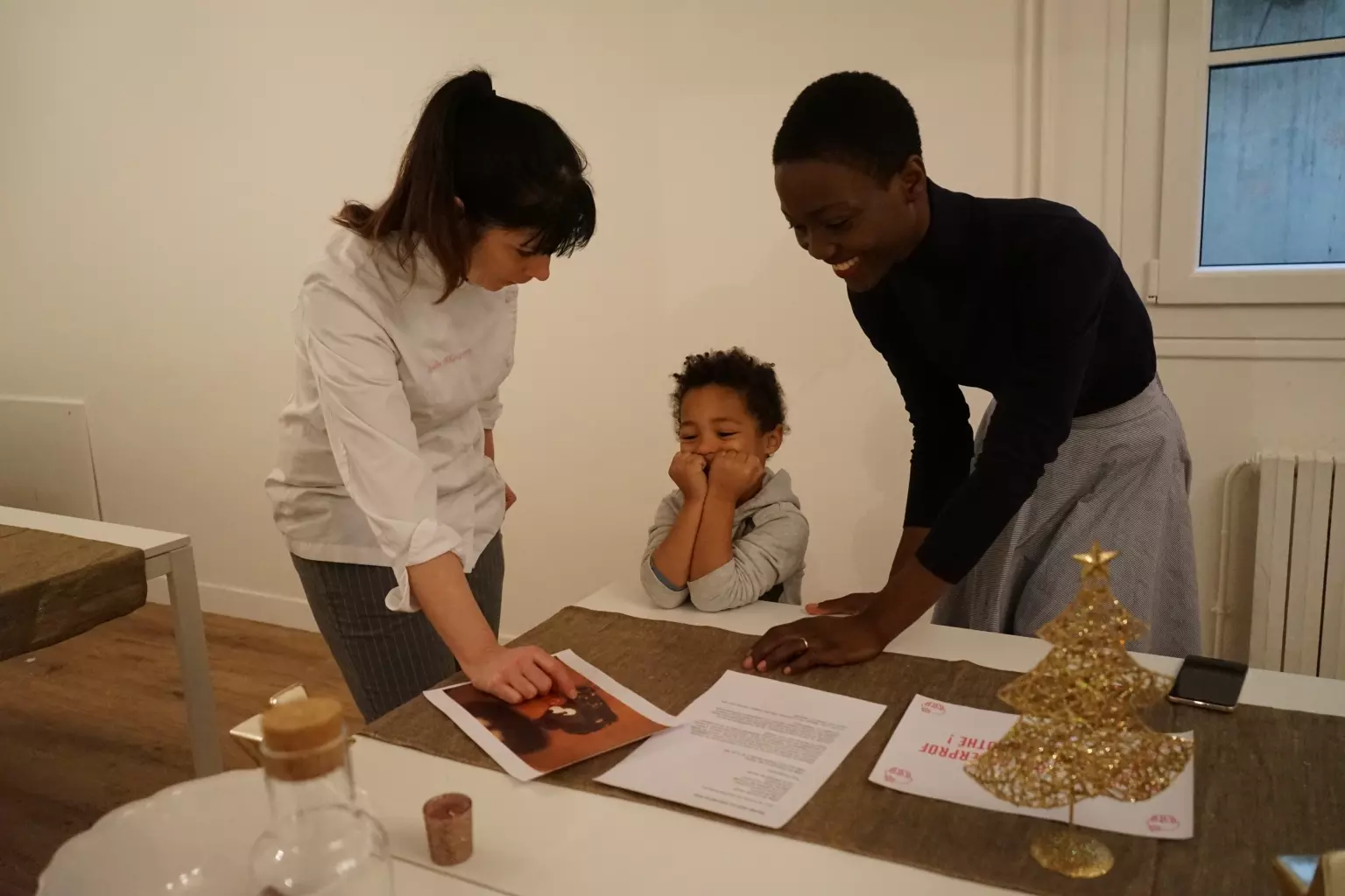 Two women and a child sitting at a desk
