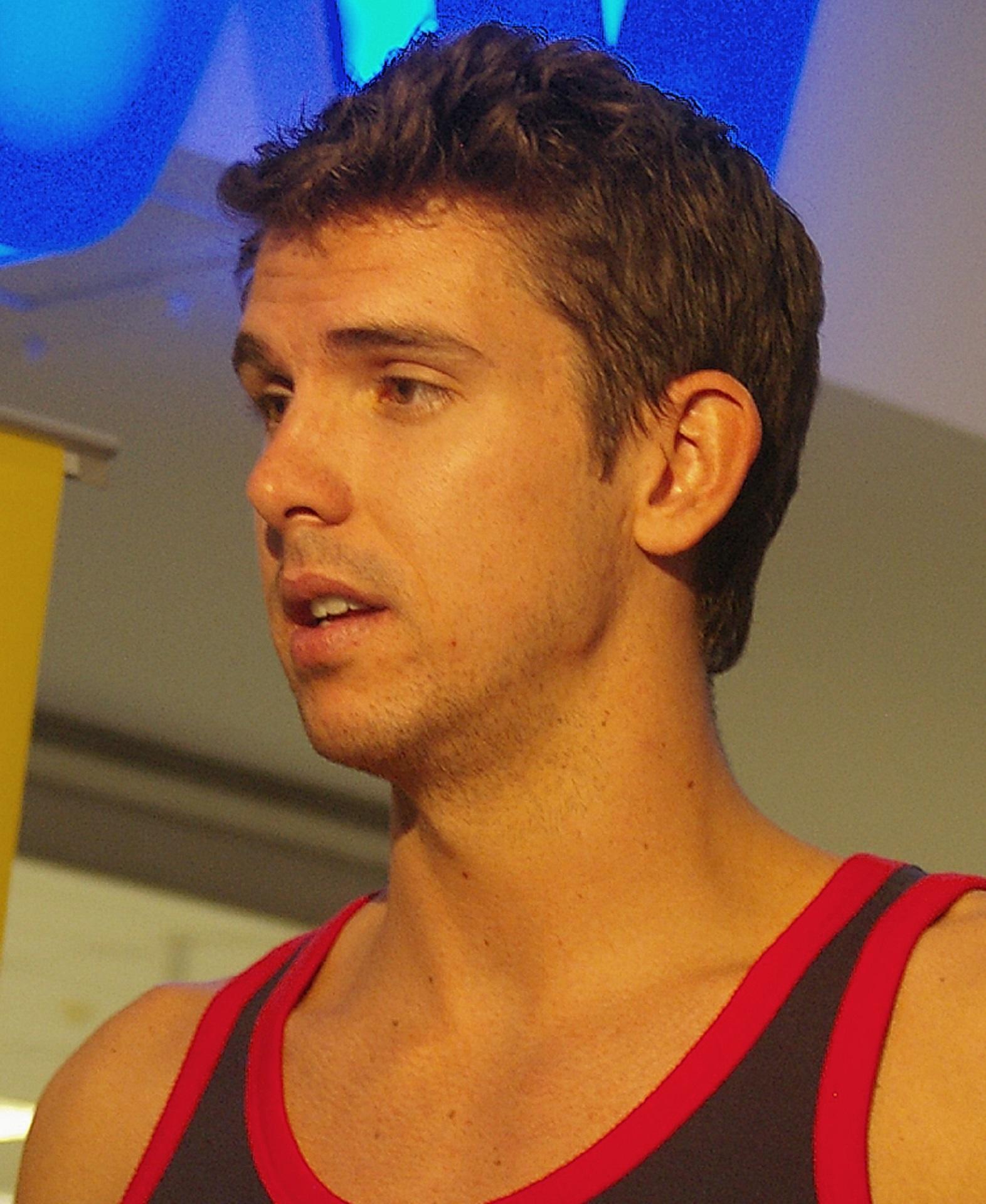 A man in a black and red tank top seen in profile. 
