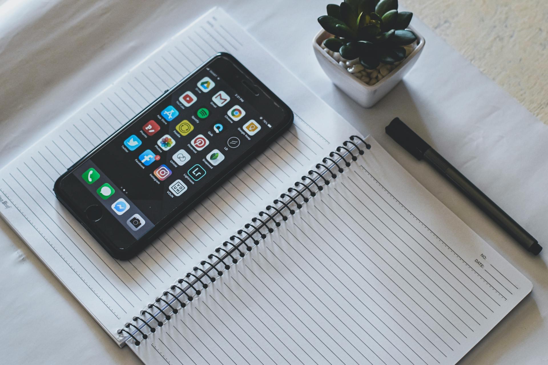 A smartphone with a notebook and pen