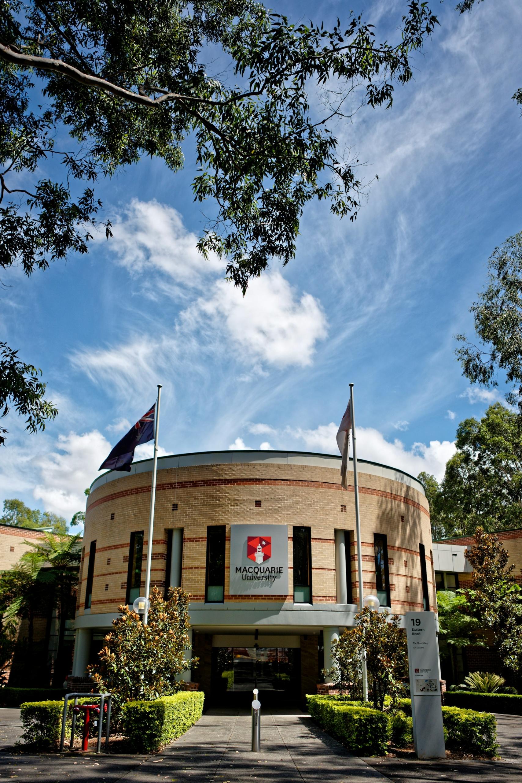 A round brick building with a sign on it on a sunny day. 
