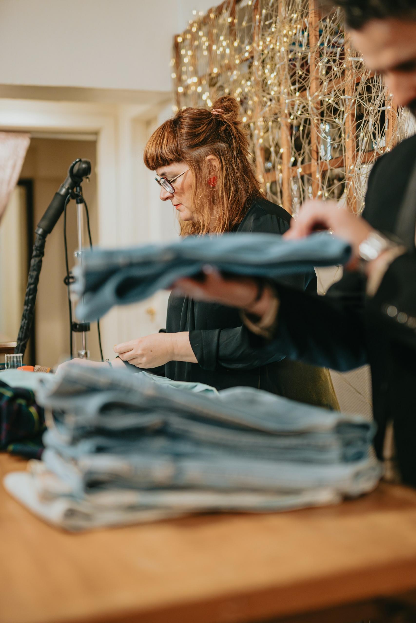 Two clerks at a counter in a clothing store.