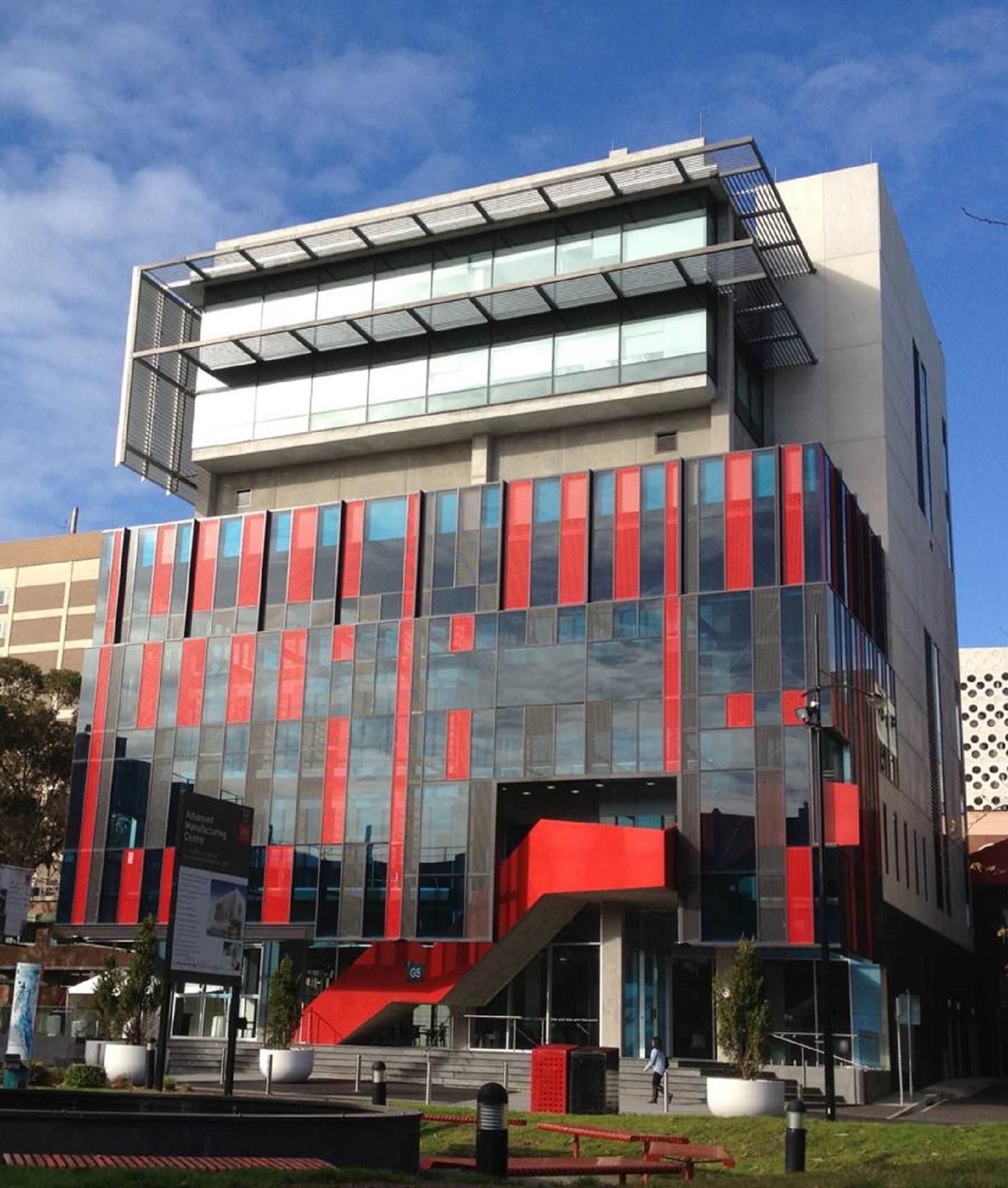 A building with a red and black facade on a sunny day. 