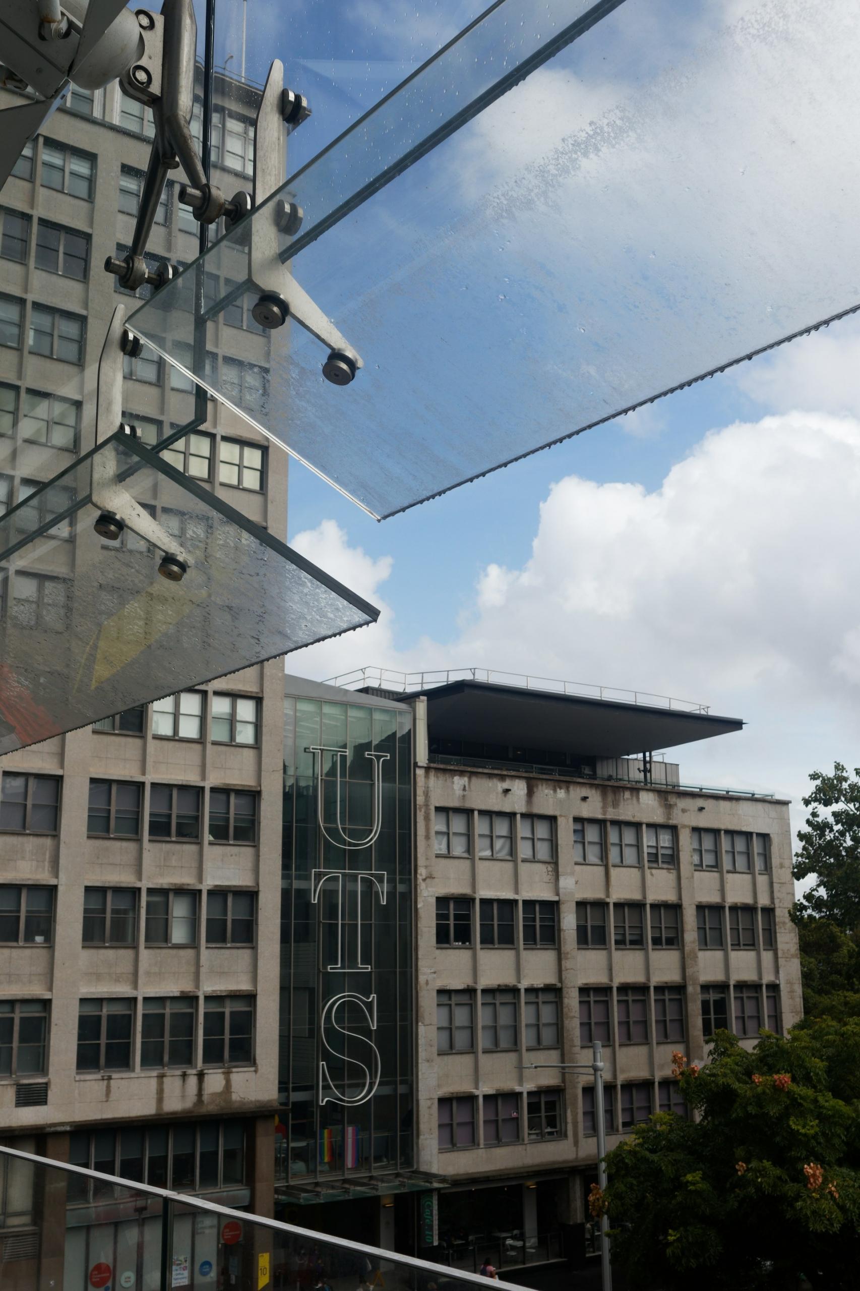 A stone and glass front building on a cloudy day. 
