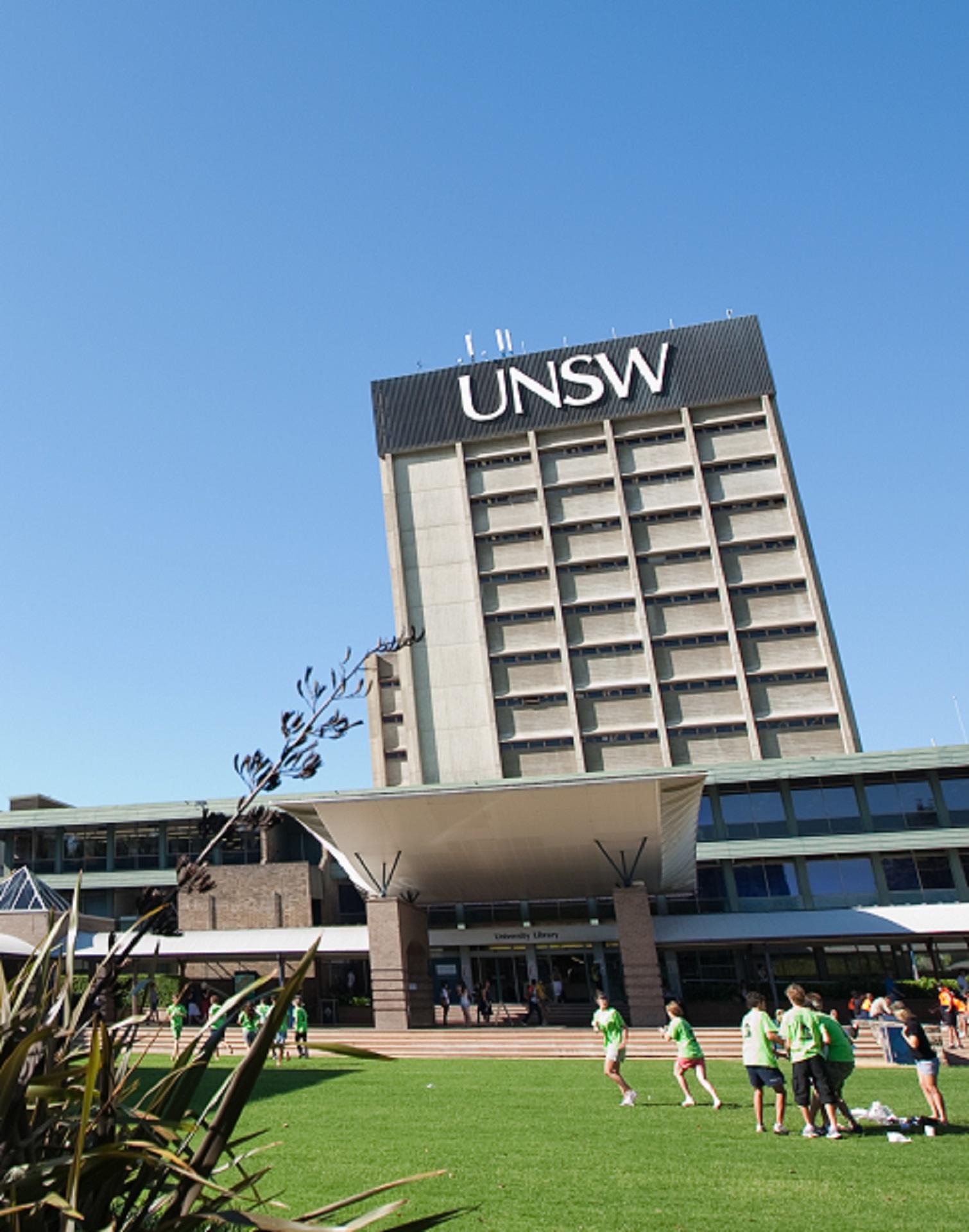 A ttall building with a black border at its top on a sunny day. 