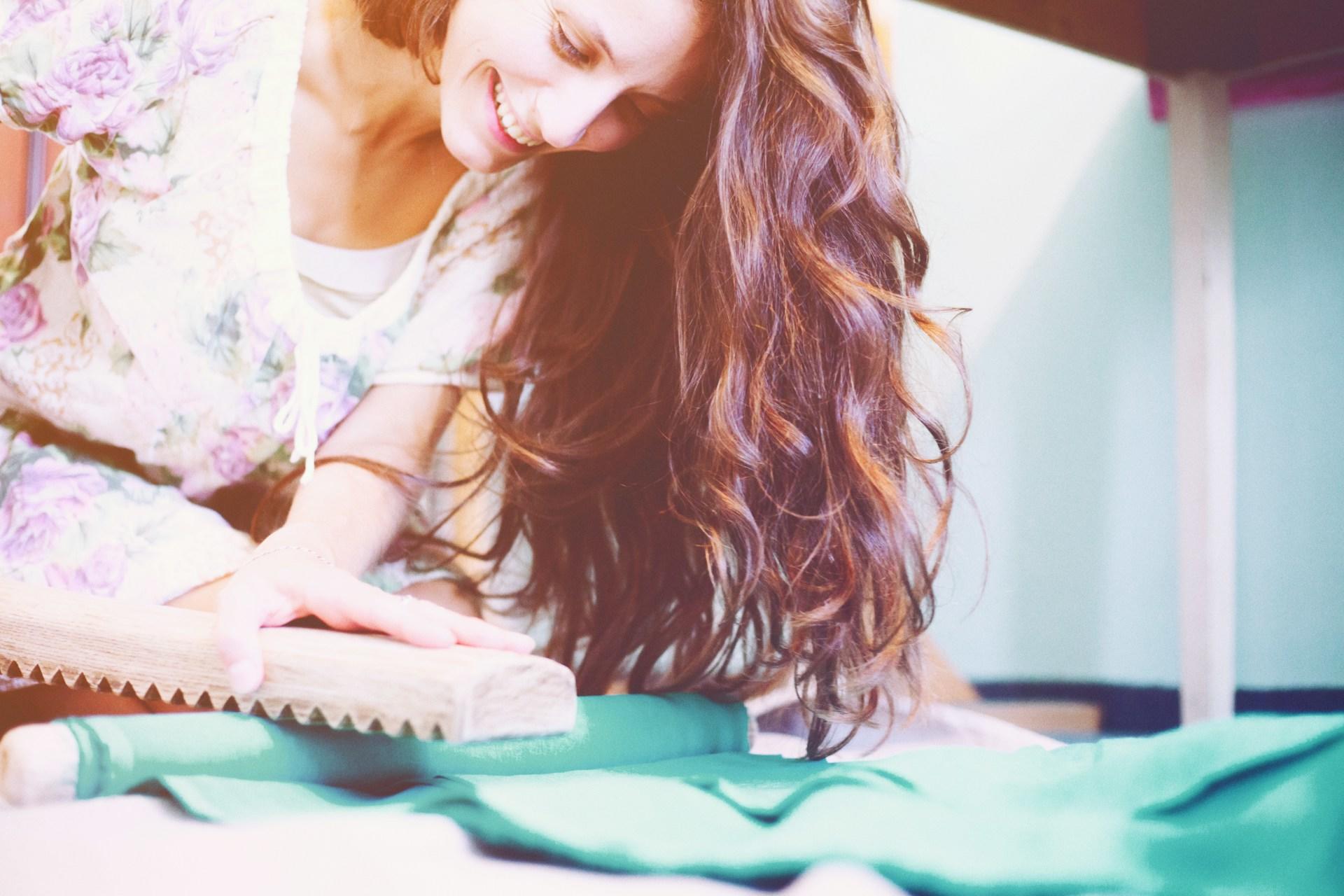 A woman preparing material for a sewing project.