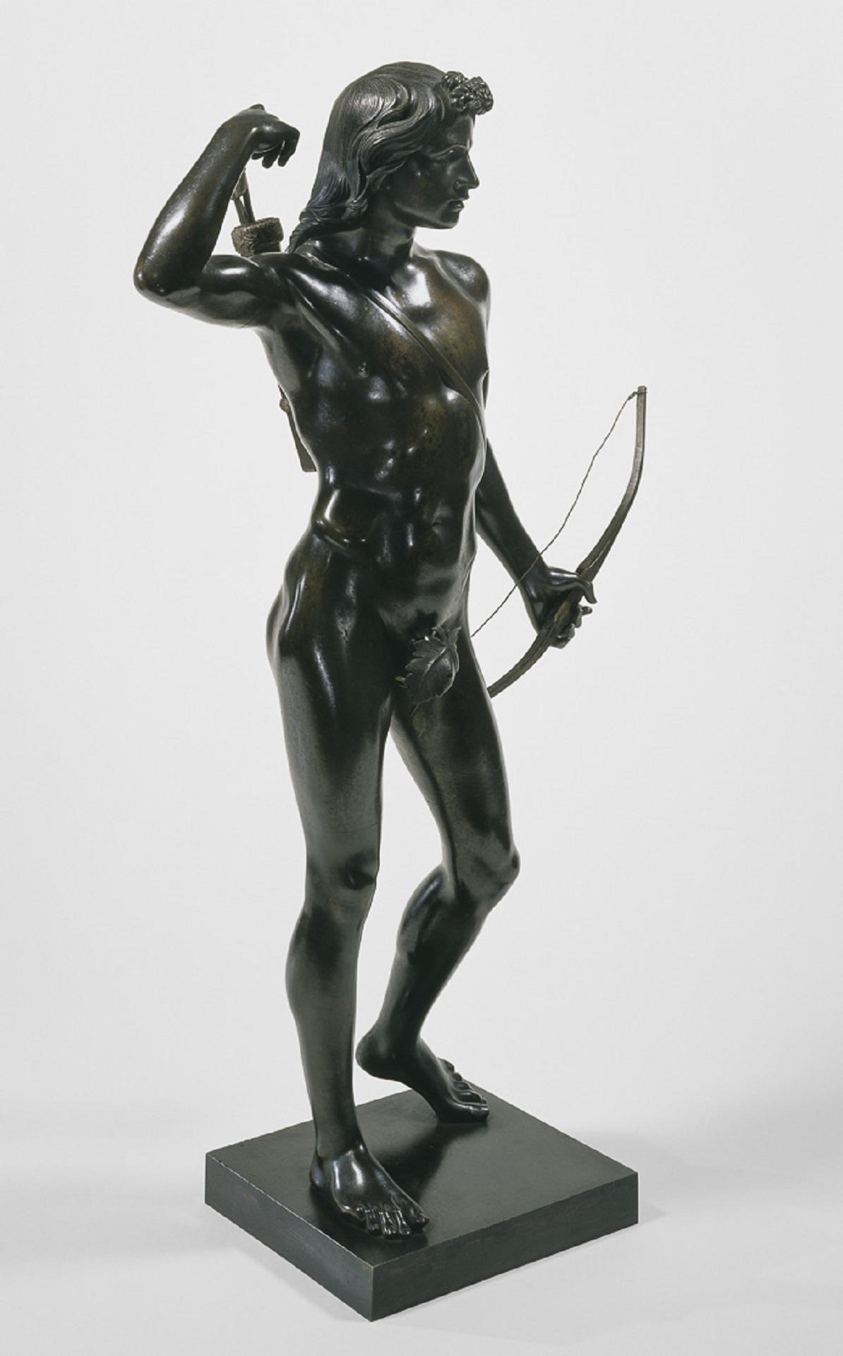 A statue of a person holding a bow and selecting an arrow. 