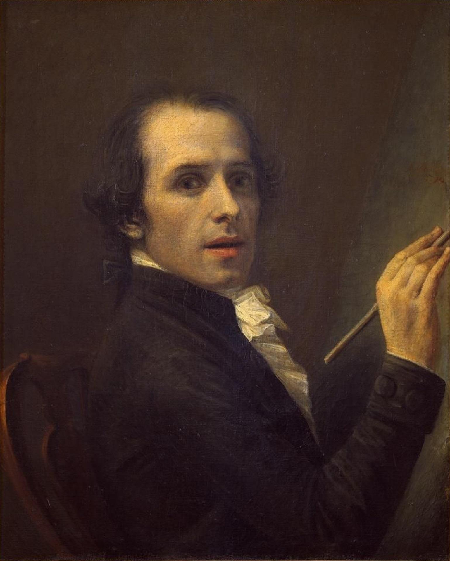 A man wearing dark clothing holds a paint brush.