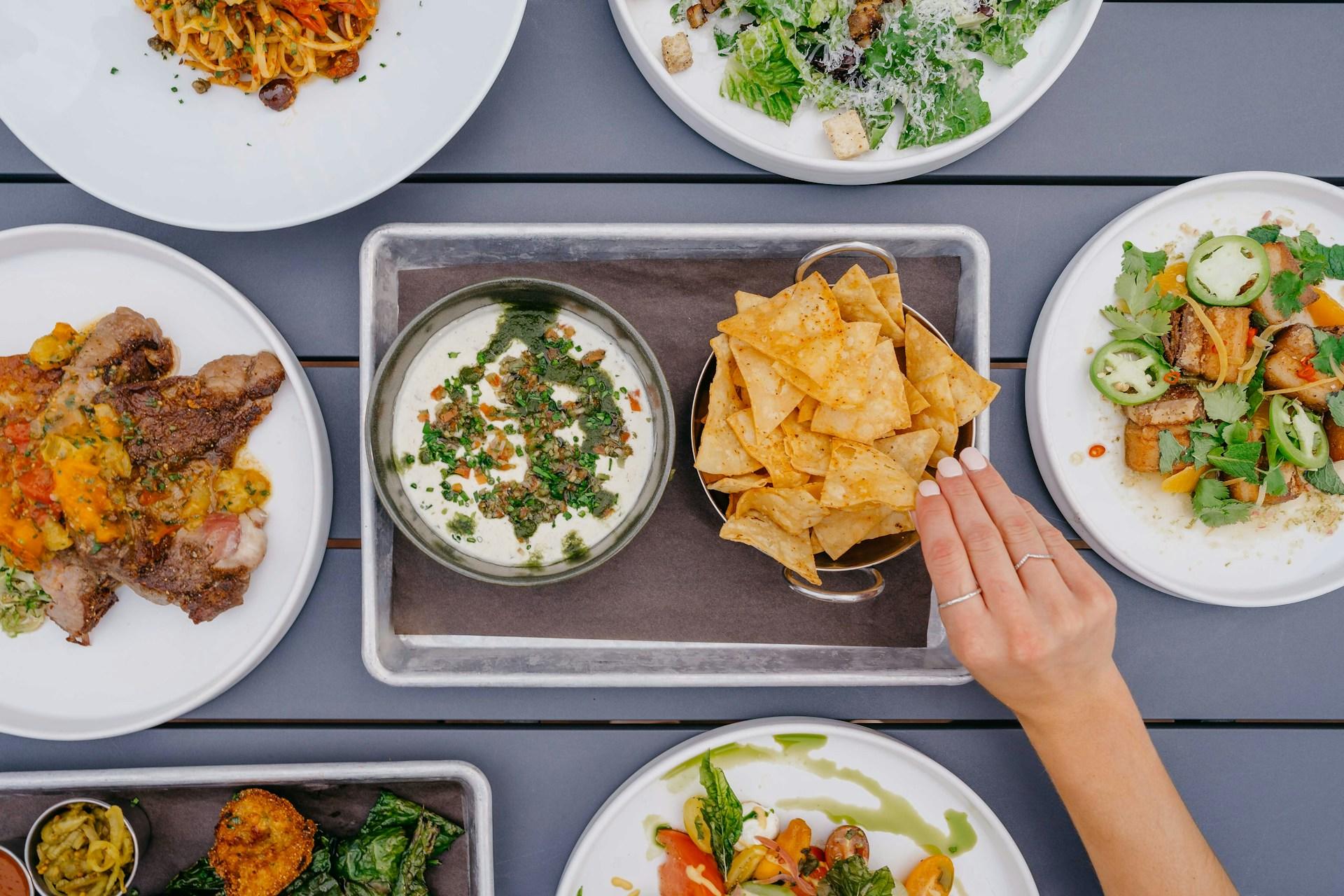 Many different plates of food on a table.