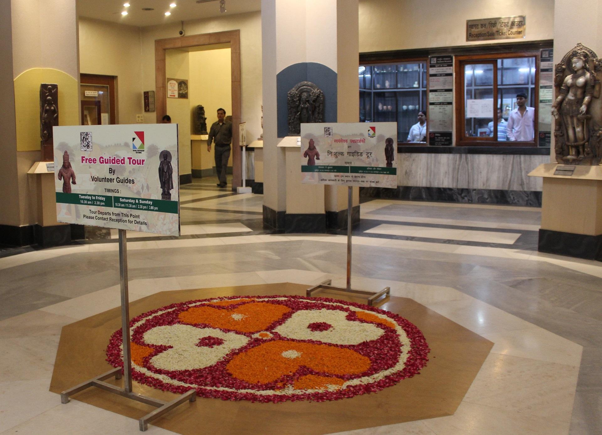 India's museum reception, with signs inviting visitors to guided tours. 
