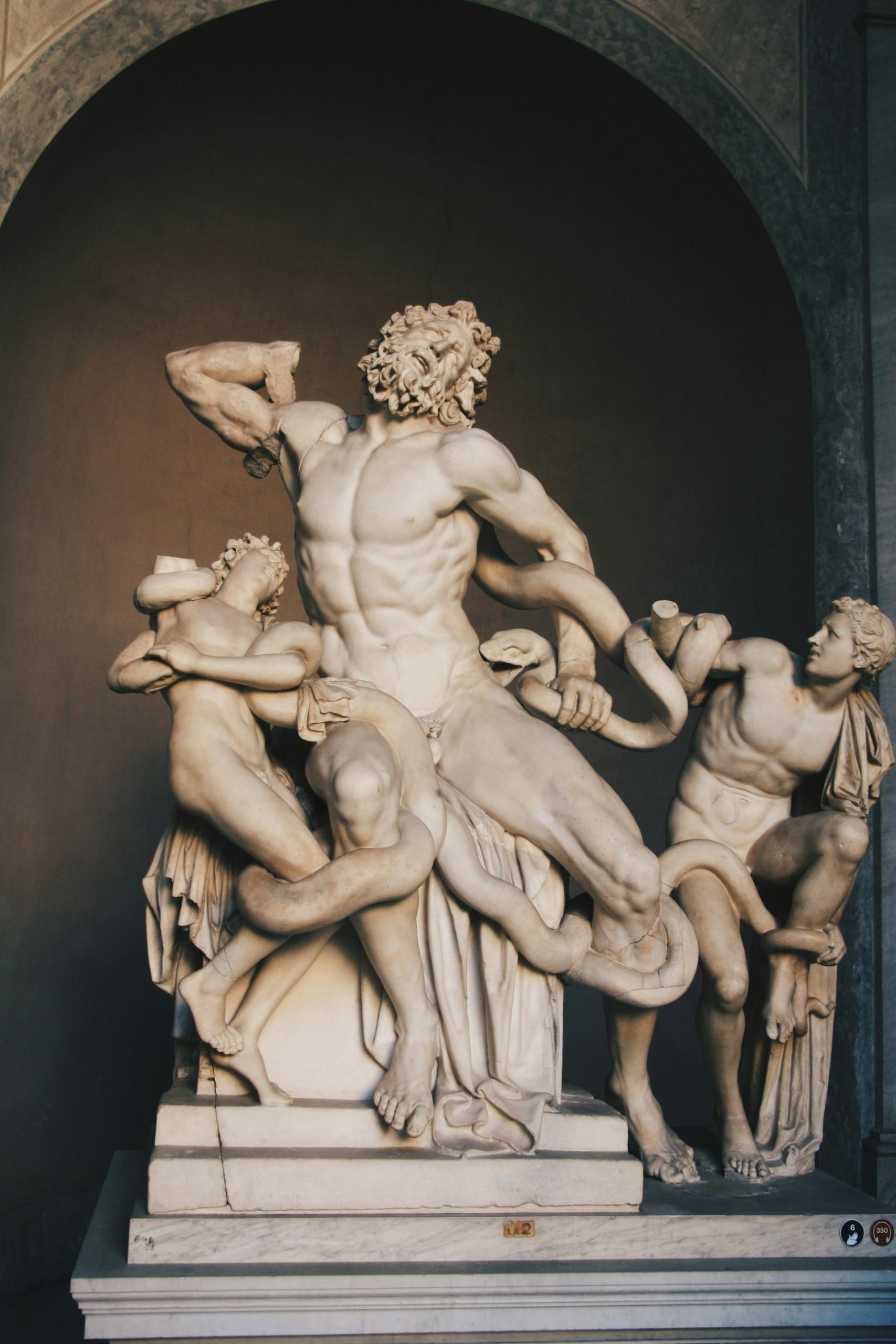 A sculpture of a male figure apparently wrestling with smaller, childlike figures.