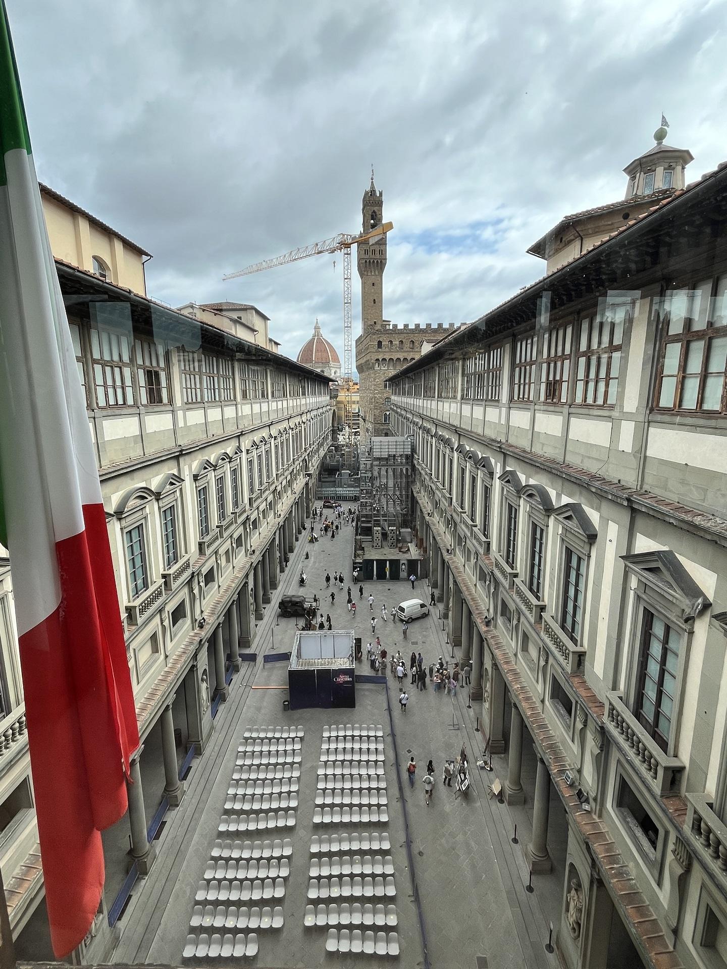 A long shot of an outdoor space flanked by two wings of a building on a cloudy day. 