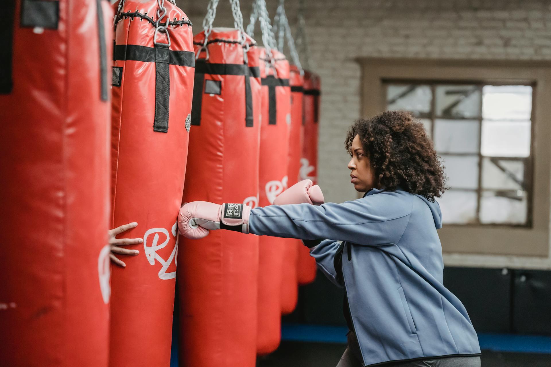 women punching a punching bag in a gym