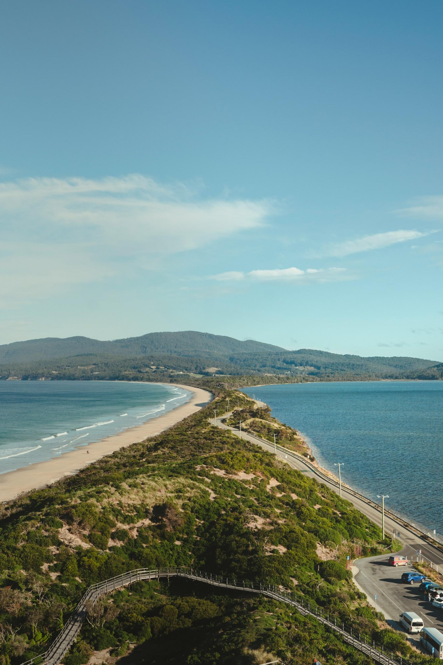 A spit of land between two bodies of water on a sunny day. 