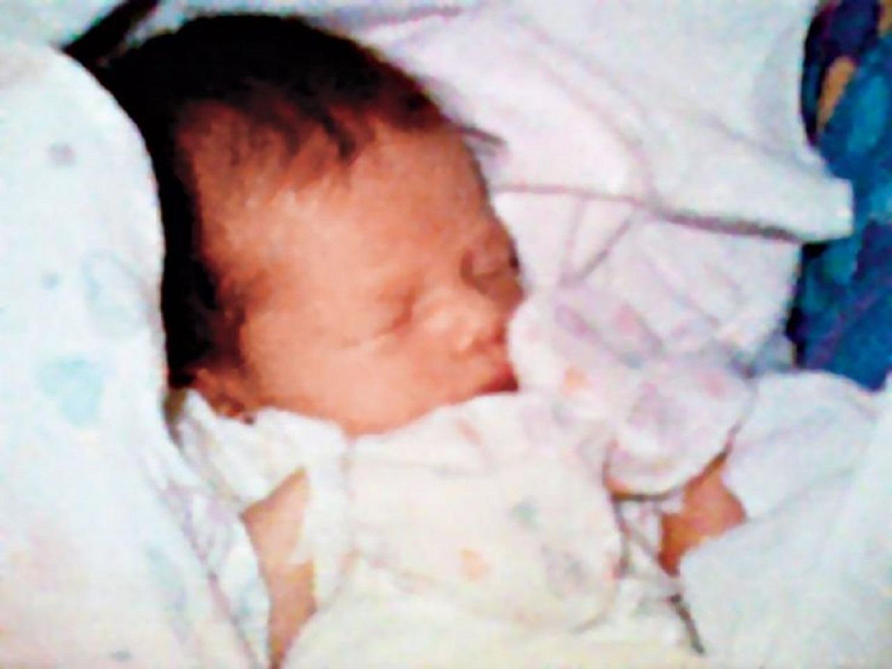 An image of a newborn baby wrapped in a white blanket.