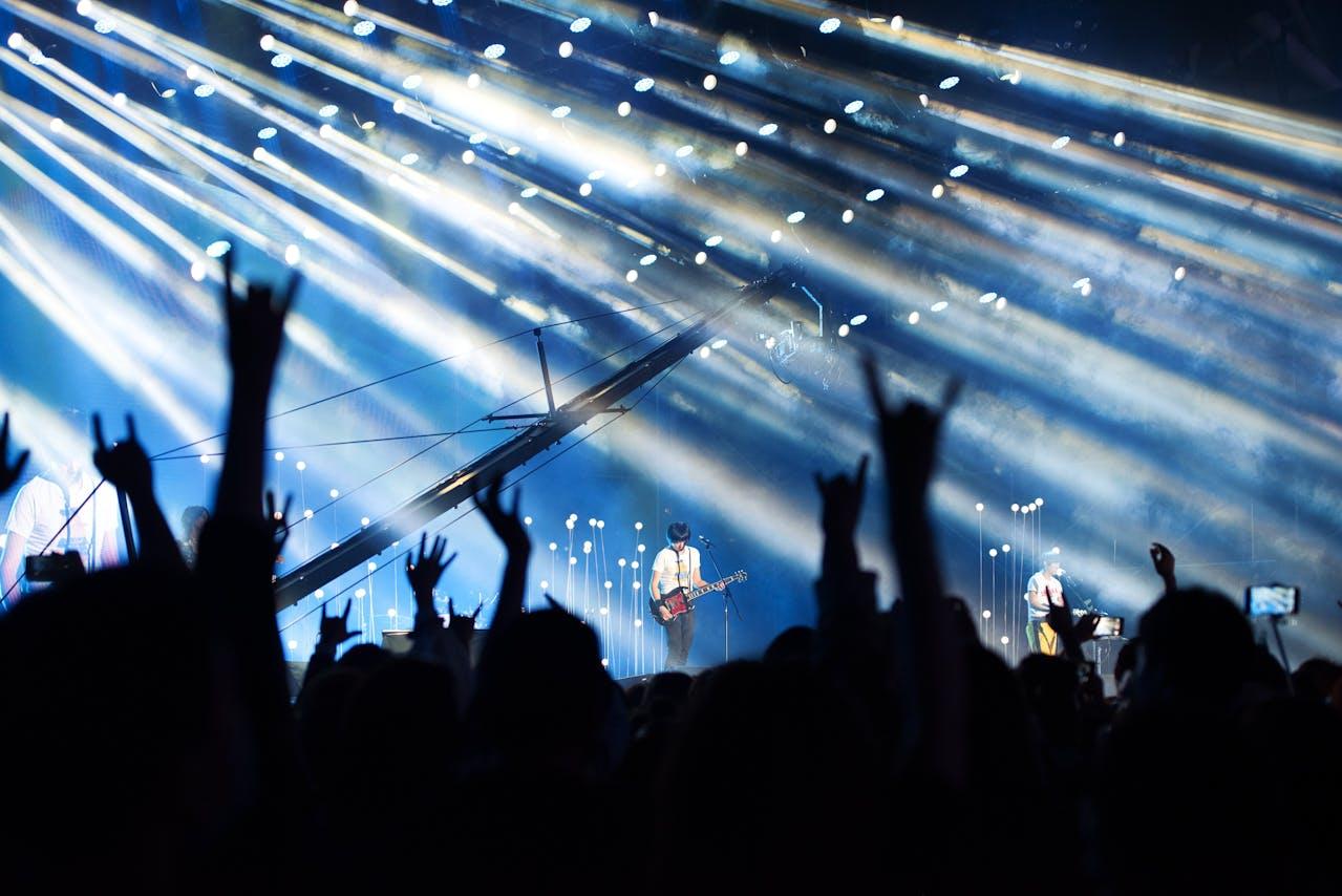 A band on stage with a cheering crowd