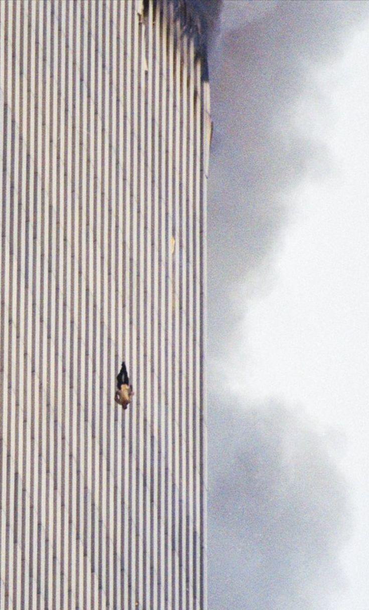 A tall white building on fire and a figure plunging to the ground.