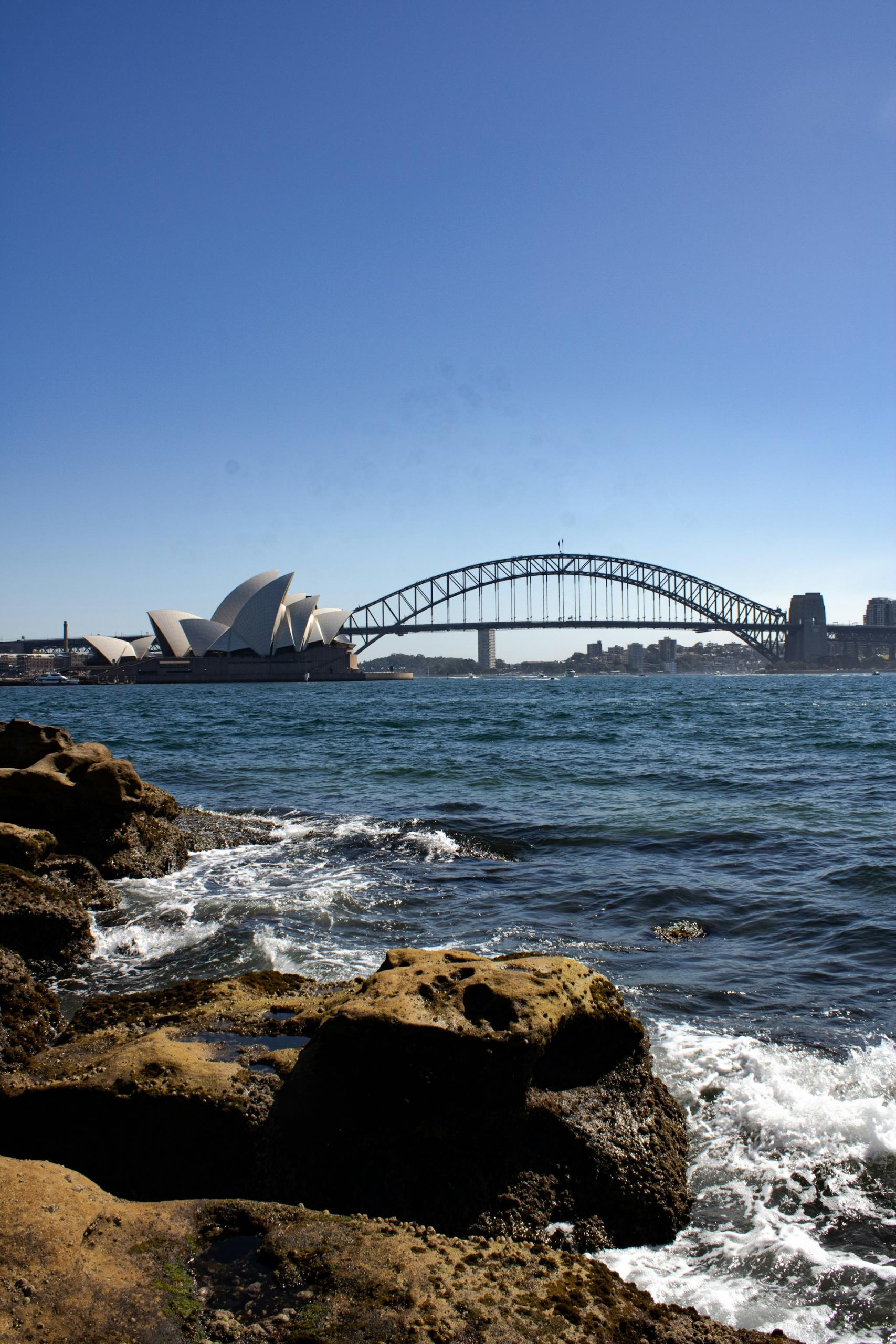 A body of water with a bridge in the distance on a sunny day.