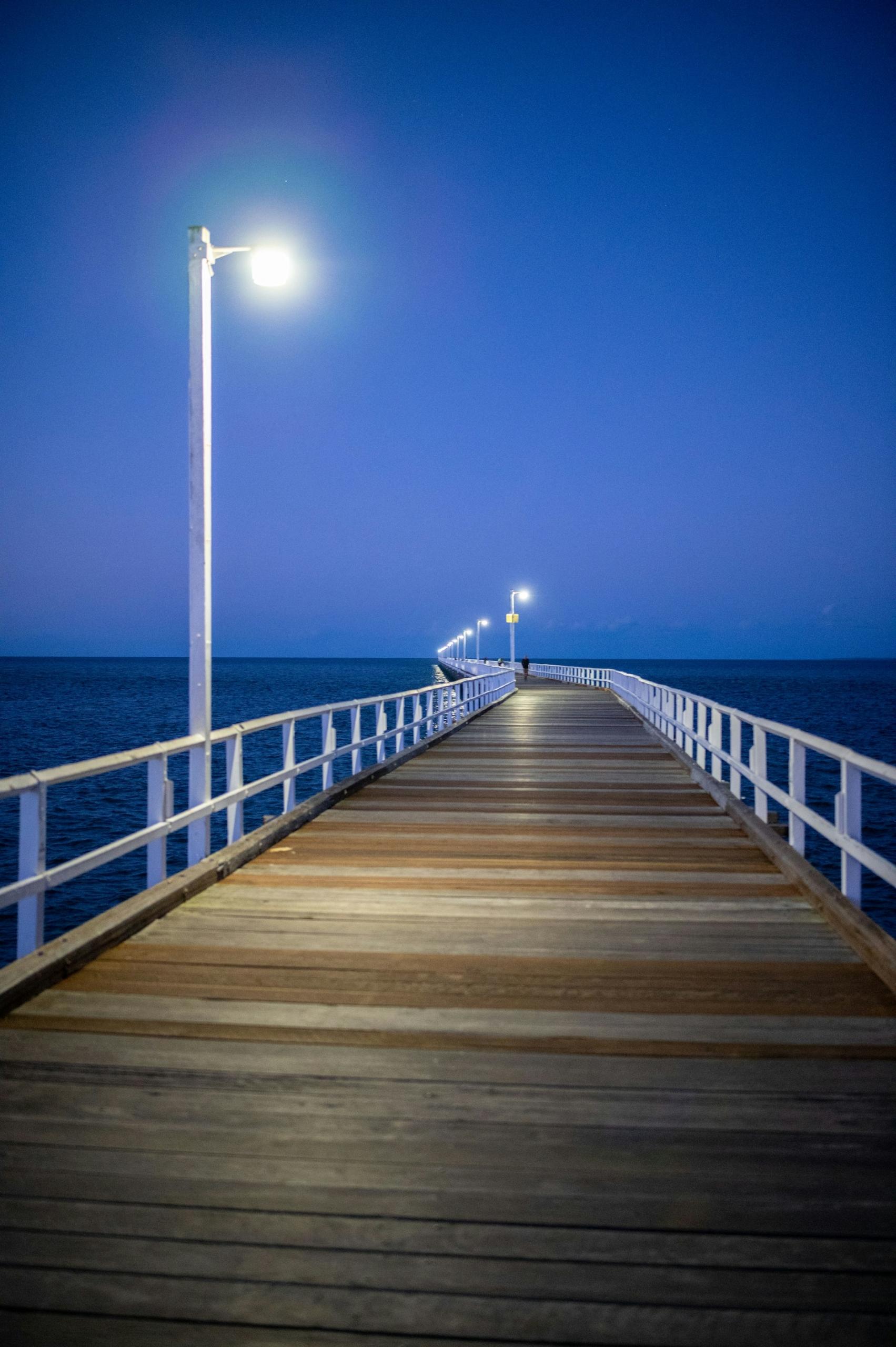 A dock jutting into the distance at night. 