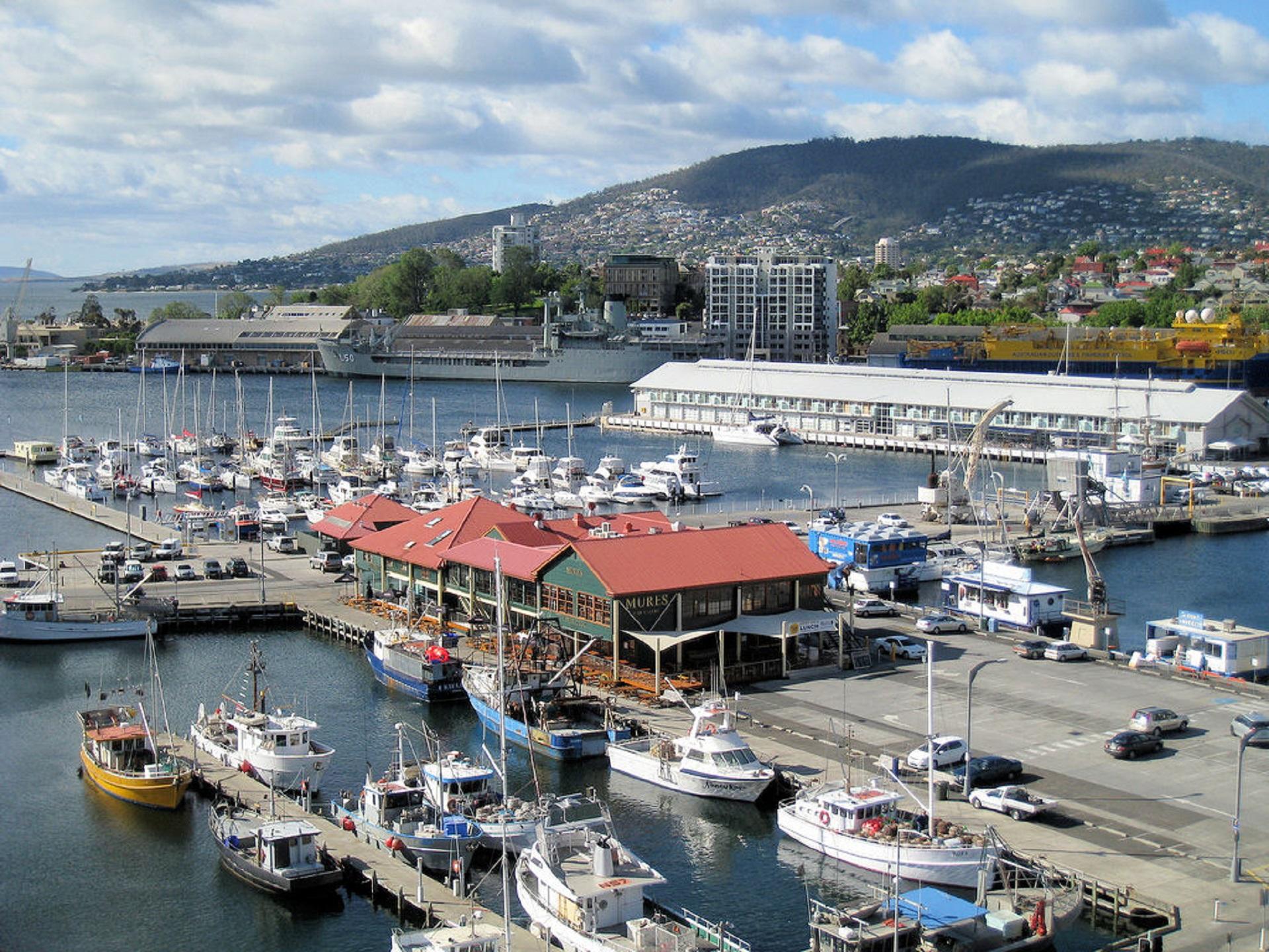 A harbour with many boats and red roofed buildings on a sunny day. 