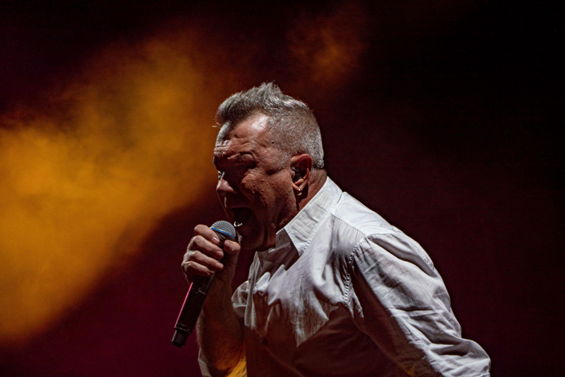 Jimmy Barnes singing into a microphone during a concert